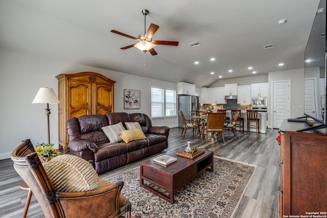 living room featuring vaulted ceiling, hardwood / wood-style floors, and ceiling fan