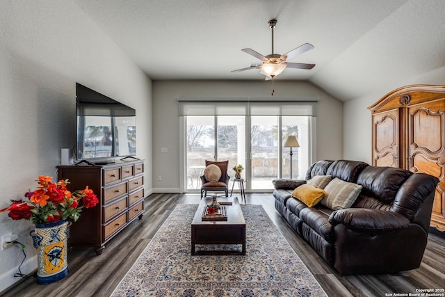 living room with ceiling fan, dark hardwood / wood-style flooring, and vaulted ceiling