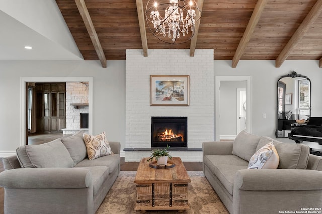 living room featuring vaulted ceiling with beams, hardwood / wood-style flooring, a notable chandelier, wood ceiling, and a brick fireplace