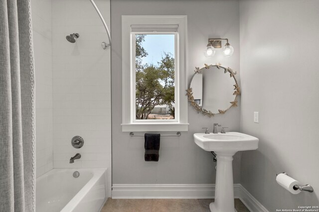 bathroom featuring tiled shower / bath and tile patterned flooring