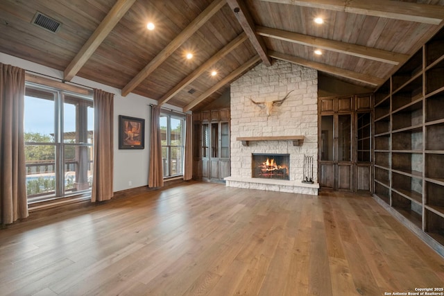 unfurnished living room featuring beam ceiling, high vaulted ceiling, wooden ceiling, a fireplace, and light hardwood / wood-style floors