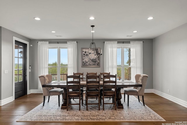 dining space with dark wood-type flooring and a chandelier