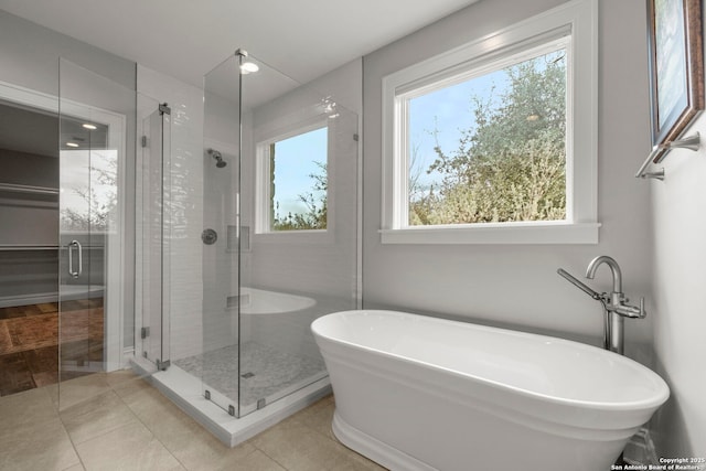 bathroom with independent shower and bath and tile patterned flooring