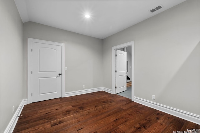 unfurnished room with dark wood-type flooring