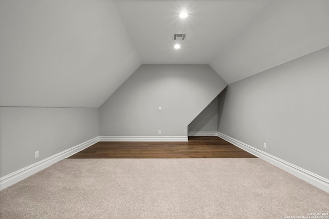 bonus room with lofted ceiling and carpet flooring