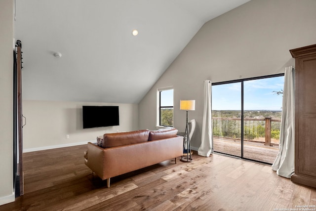 living room with vaulted ceiling, plenty of natural light, and light hardwood / wood-style floors