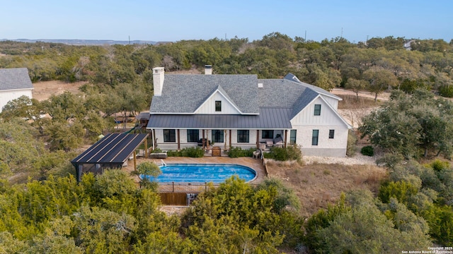 back of house featuring solar panels