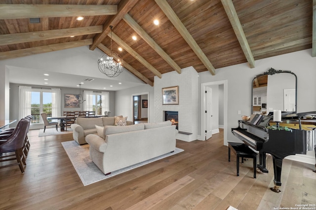 living room featuring an inviting chandelier, light hardwood / wood-style floors, and wooden ceiling