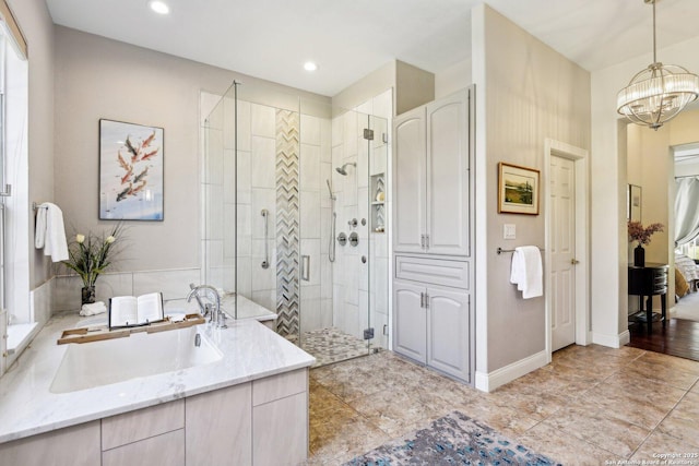 bathroom featuring plus walk in shower, sink, and a chandelier