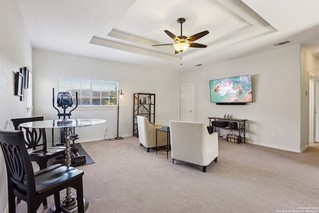 carpeted living room featuring a raised ceiling, crown molding, and ceiling fan