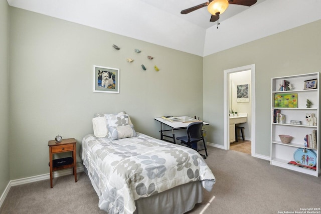 bedroom with ceiling fan, ensuite bathroom, vaulted ceiling, and light carpet