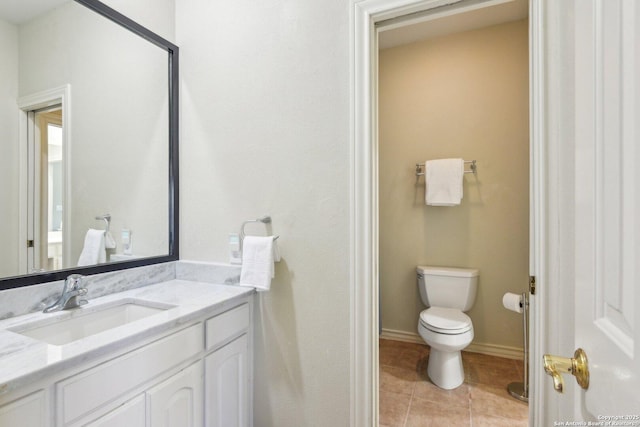 bathroom featuring tile patterned flooring, vanity, and toilet