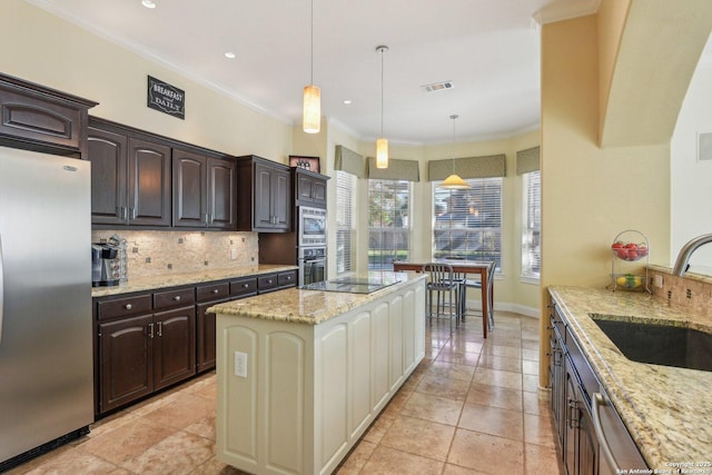 kitchen with pendant lighting, dark brown cabinetry, light stone countertops, and appliances with stainless steel finishes