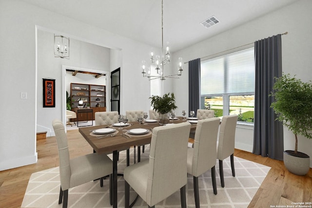 dining space featuring a notable chandelier and light hardwood / wood-style flooring