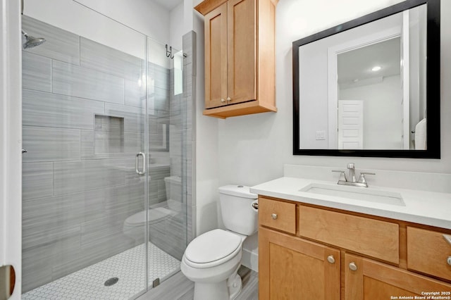 bathroom featuring vanity, toilet, and walk in shower