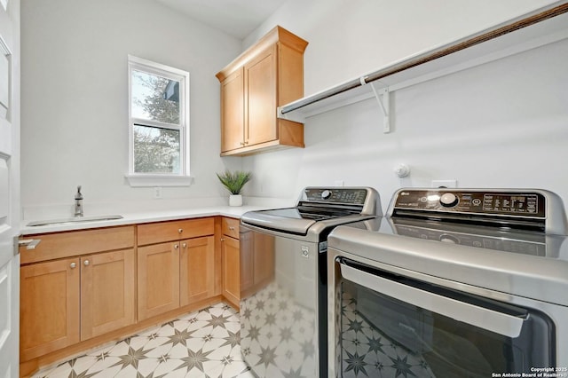 laundry area with cabinets, washing machine and dryer, and sink