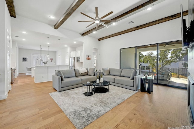 living room with beam ceiling, ceiling fan with notable chandelier, and light hardwood / wood-style floors