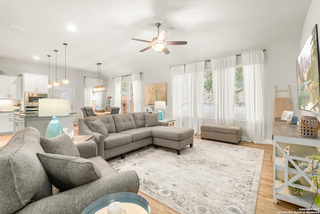 living room featuring ceiling fan and light hardwood / wood-style floors