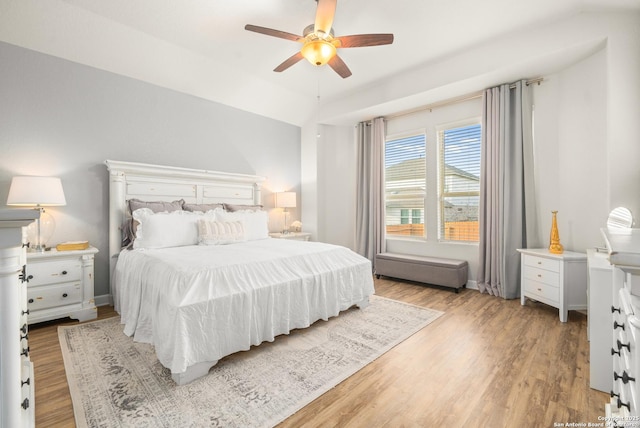 bedroom with vaulted ceiling, light hardwood / wood-style floors, and ceiling fan