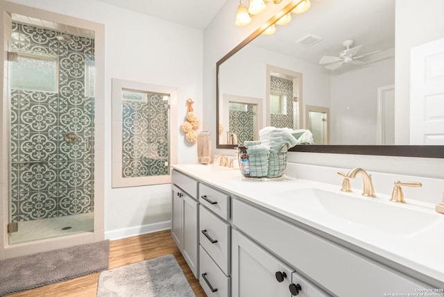 bathroom with ceiling fan, vanity, hardwood / wood-style floors, and a tile shower