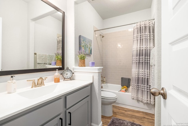 full bathroom featuring wood-type flooring, vanity, toilet, a textured ceiling, and shower / bath combo with shower curtain