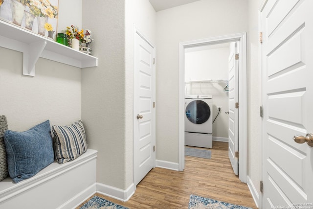 clothes washing area featuring washer / clothes dryer and light hardwood / wood-style floors