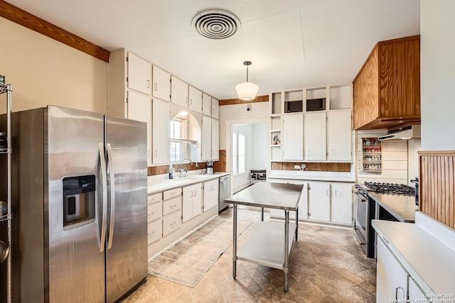 kitchen featuring sink, pendant lighting, white cabinetry, beamed ceiling, and stainless steel appliances