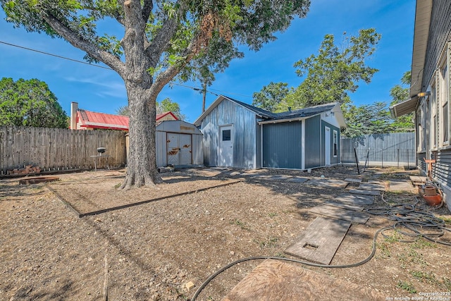 back of house with a storage shed