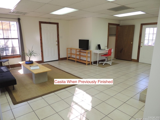 tiled living room with a paneled ceiling and a healthy amount of sunlight