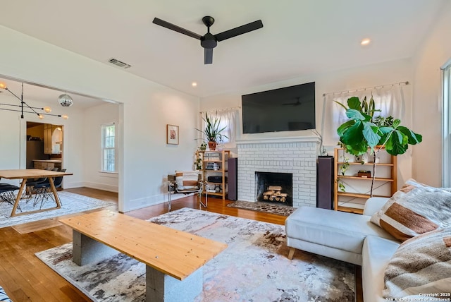 living room with ceiling fan, a fireplace, and hardwood / wood-style floors