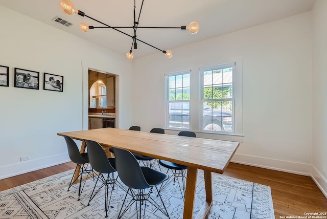 dining area featuring light hardwood / wood-style floors and a chandelier