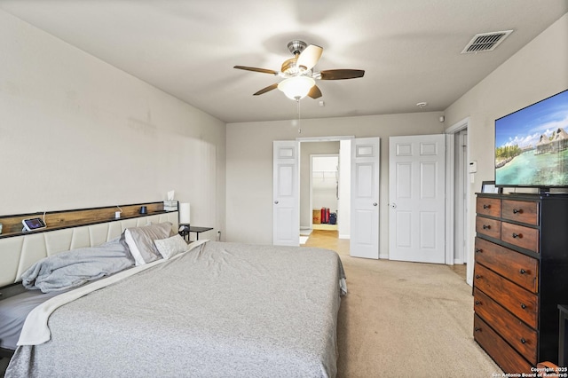 carpeted bedroom with ceiling fan and ensuite bathroom