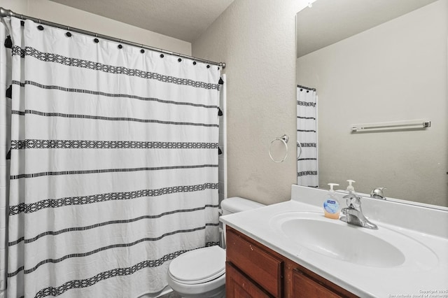 bathroom featuring vanity, a textured ceiling, and toilet