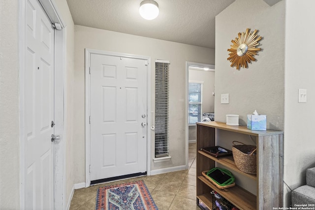 tiled foyer entrance with a textured ceiling