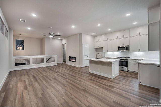 kitchen featuring white cabinetry, appliances with stainless steel finishes, sink, and light wood-type flooring