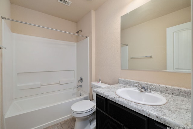 full bathroom with vanity, hardwood / wood-style flooring, shower / bathtub combination, and toilet