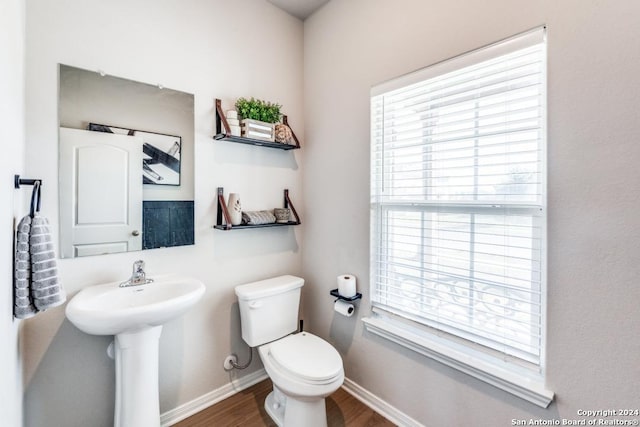 bathroom featuring hardwood / wood-style flooring, a healthy amount of sunlight, and toilet