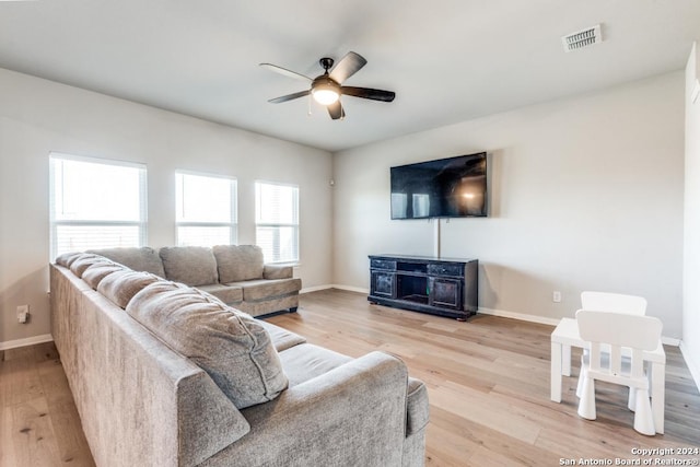 living room with light hardwood / wood-style floors and ceiling fan