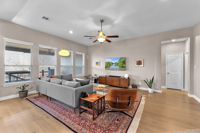 living room featuring ceiling fan and light hardwood / wood-style flooring