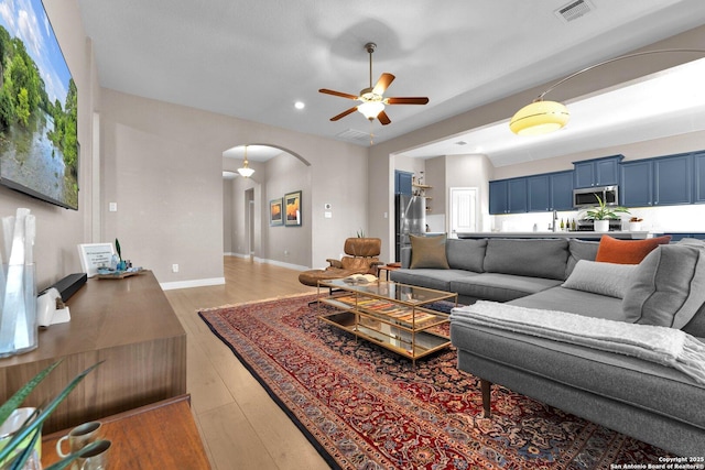 living room featuring ceiling fan and dark hardwood / wood-style floors