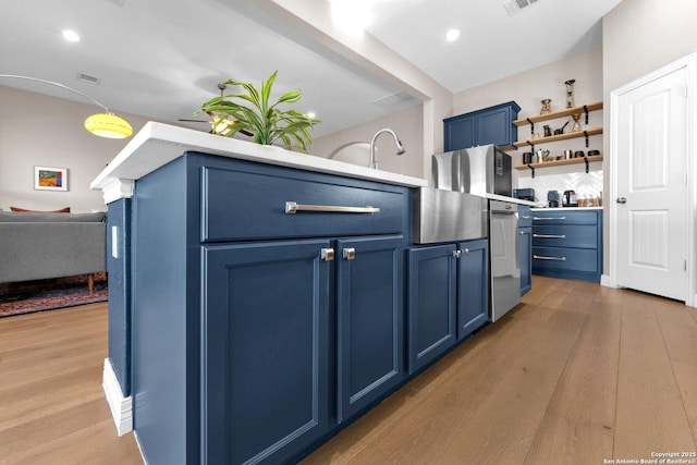 kitchen with blue cabinets, sink, and light hardwood / wood-style floors