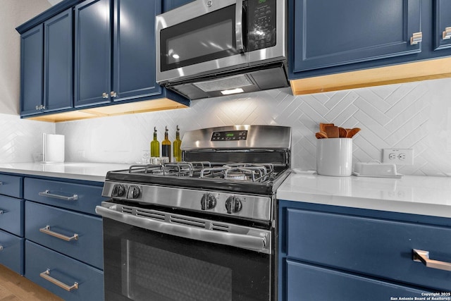 kitchen featuring decorative backsplash, blue cabinetry, and appliances with stainless steel finishes