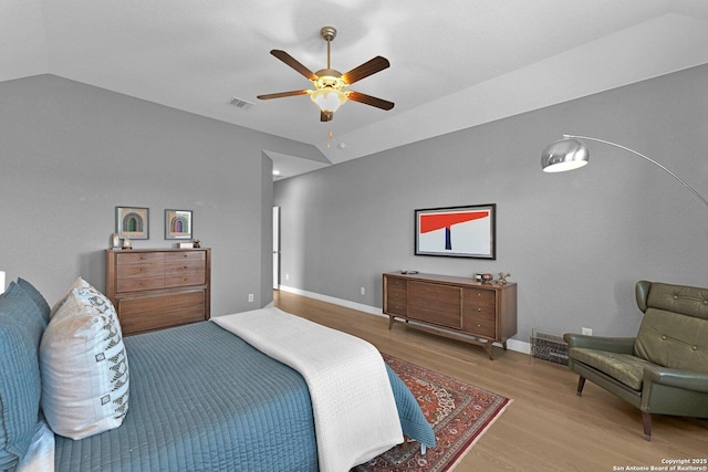 bedroom featuring ceiling fan, light hardwood / wood-style floors, and vaulted ceiling