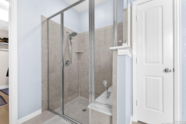 bathroom with tile patterned floors and a shower with shower door