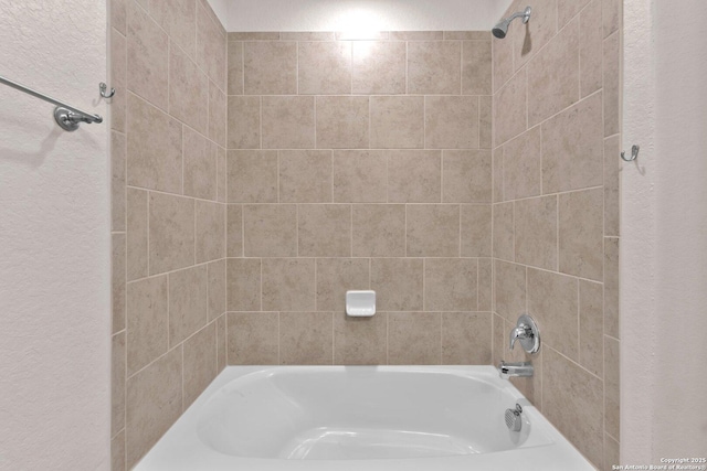 bathroom featuring tiled shower / bath