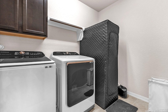 laundry area with cabinets, light tile patterned floors, and independent washer and dryer