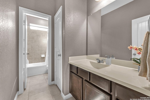 full bathroom featuring tile patterned flooring, vanity, tiled shower / bath combo, and toilet