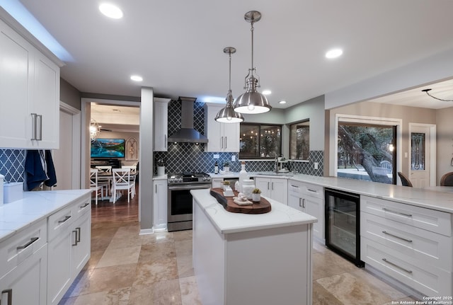 kitchen featuring wine cooler, stainless steel range, wall chimney exhaust hood, and white cabinets