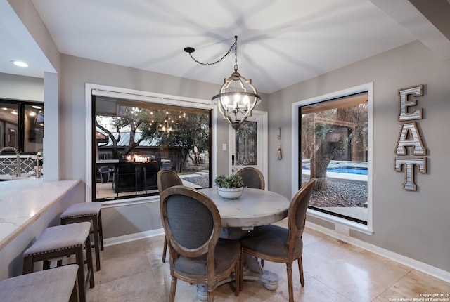 tiled dining area featuring a chandelier