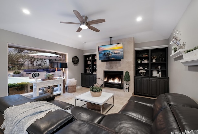 living room with a tiled fireplace and ceiling fan